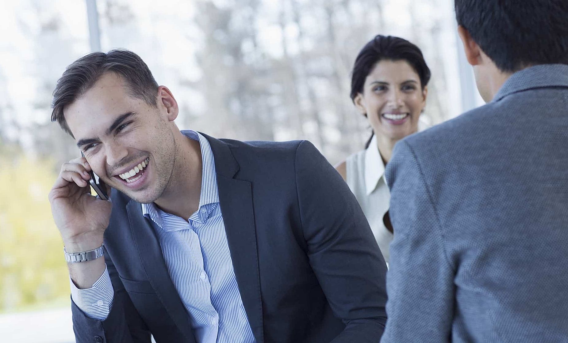 Happy businessman talking on smart phone and laughing