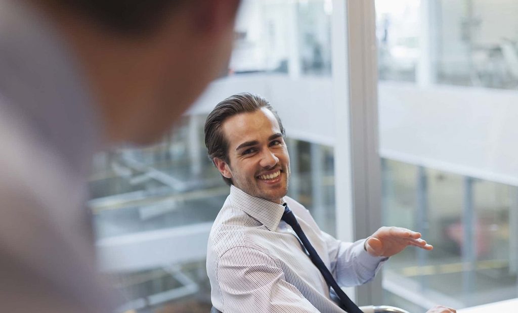 Smiling corporate businessmen talking in office
